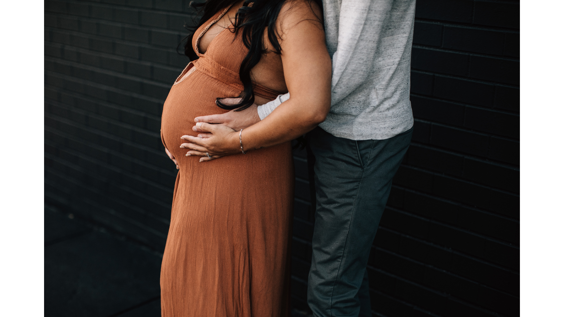 pregnant person with partner holding belly