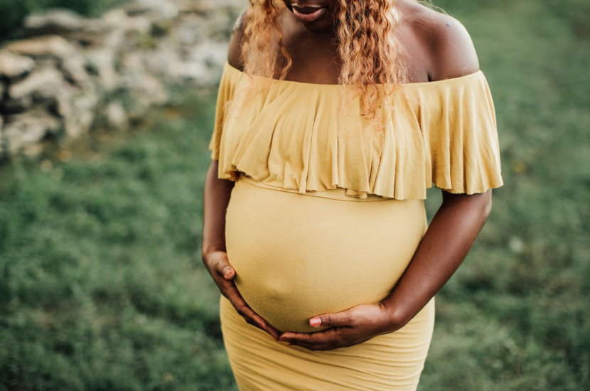 Black pregnant woman cradling her stomach